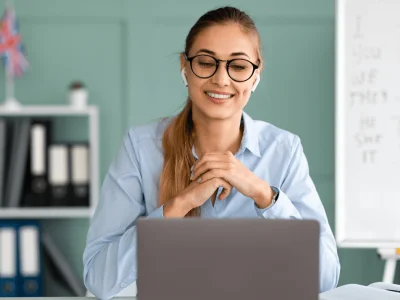 Mujer con auriculares participando en una videollamada, discutiendo los detalles del cambio de denominacion social con su equipo.