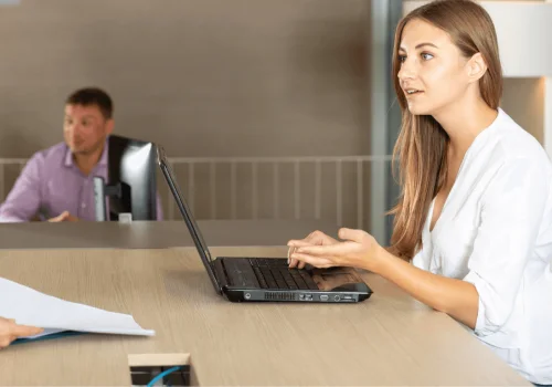 A woman talks with a legal advisor while holding documents, managing her online termination of domestic partnership certificate
