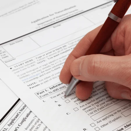 Person completing an official form, a key step in applying for Online Minor Travel Authorizations.