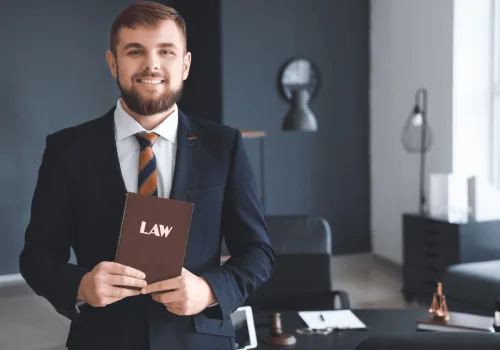 A lawyer holds a law book in their office, providing expert guidance