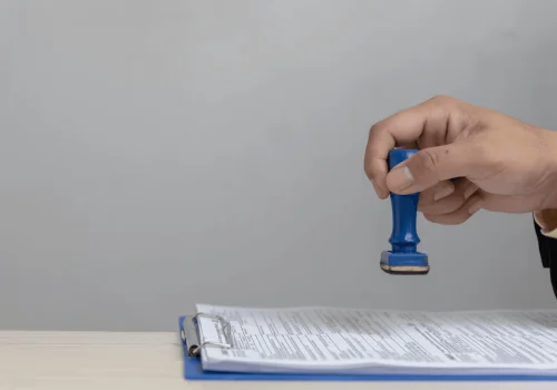 Person certifying a document with a blue seal.