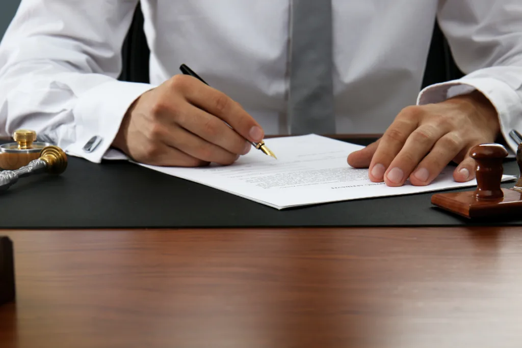Manos de un profesional firmando un documento oficial en una mesa de trabajo, ejemplificando la validez legal del Certificado de Convivencia Online.